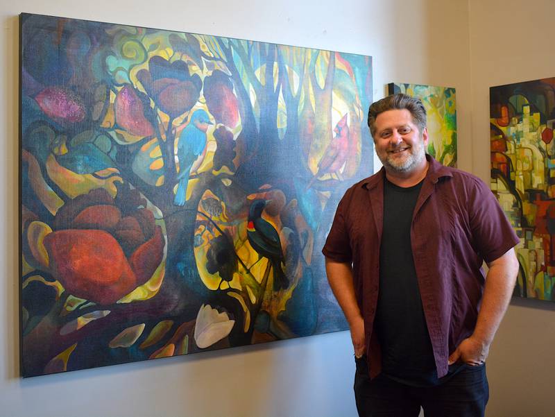 Chad Elliott stands beside one of the paintings in his "Old Current" exhibit. The painting took a week to finalize.