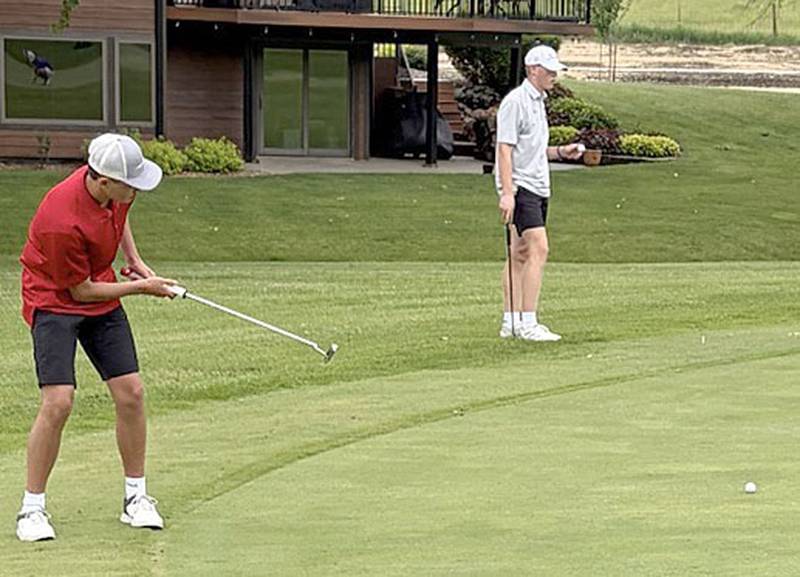Creston's Branden Spencer (left) putts during Monday's district tournament in Atlantic. Spencer shot an 88 in his first district appearance.
