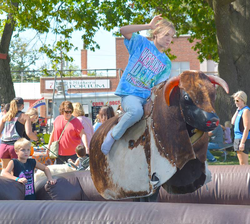 A girl rides a bucking mechanical bull during Afton Autumn Days in 2024.