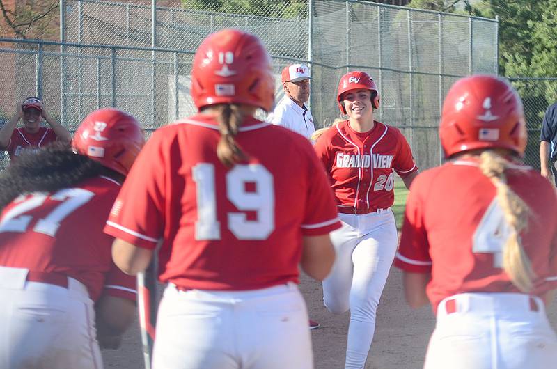 Grand View's Nevaeh Randall (20) is greeted by teammates at home plate after blasting a two-run home run in Wednesday's doubleheader sweep of league rival Benedictine College. Randall has five homers and 31 RBIs for the Vikings.