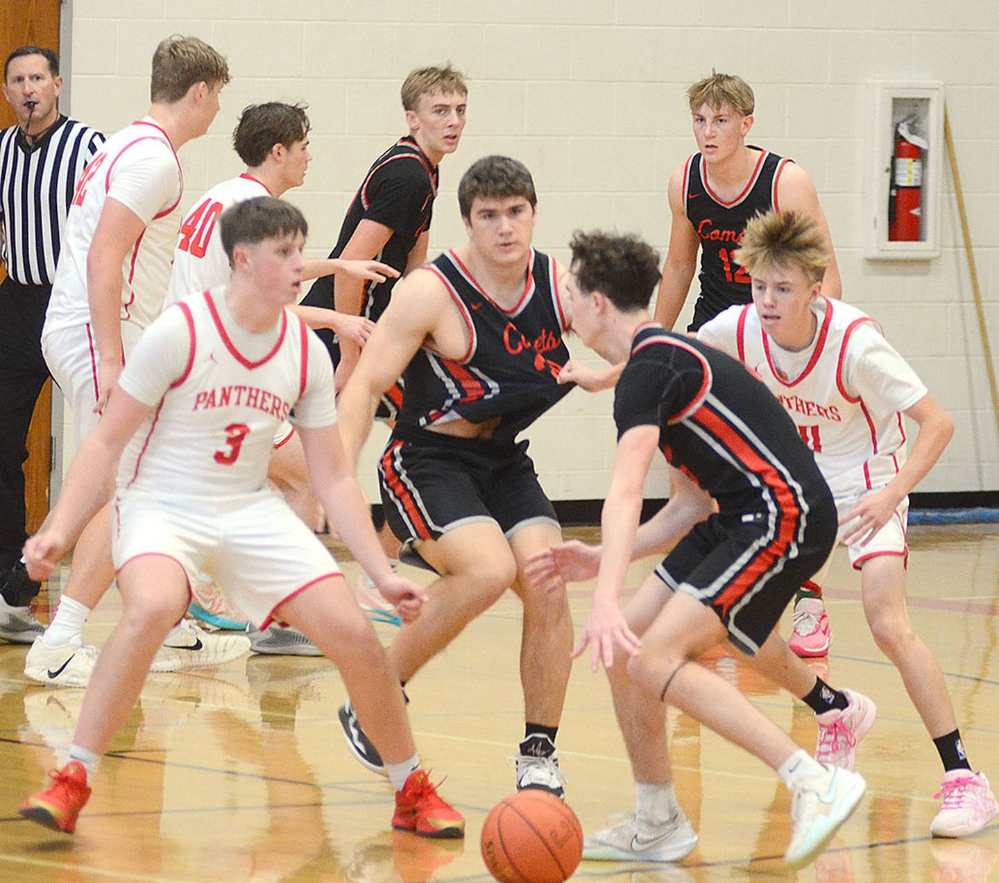 North Polk's Aaron Ausborn dribbles against Creston defenders Rhett Driskell (3) and Garrett Troutwine (right).