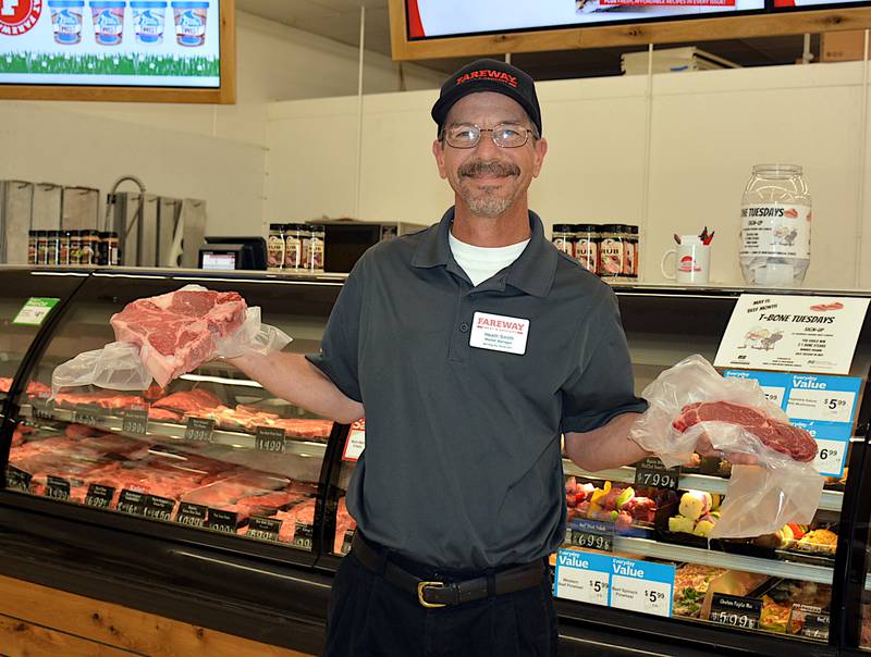 Heath Smith shows off two different cuts of steak at the Fareway meat counter. Smith was named Friend of the Adair County Cattlemen in January at the group's annual banquet.