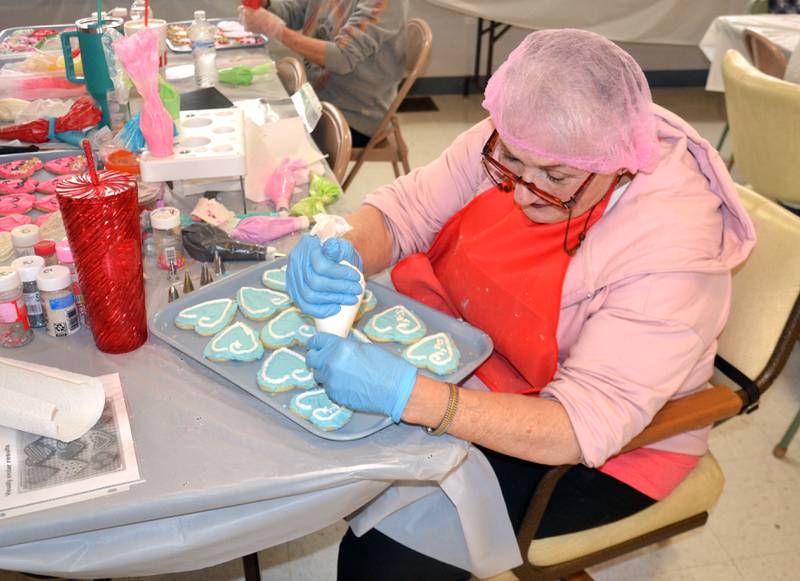 Nancy Stringer decorates a tray of cookies for the annual Friends of the Library cookie sale. The Friends had over 3,000 cookies ordered.