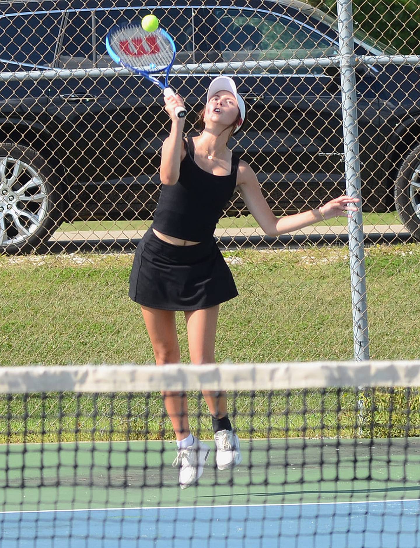 Savannah Jaques serves to Red Oak during doubles play in Tuesday's home meet. Jaques was one of four seniors honored prior to the match.