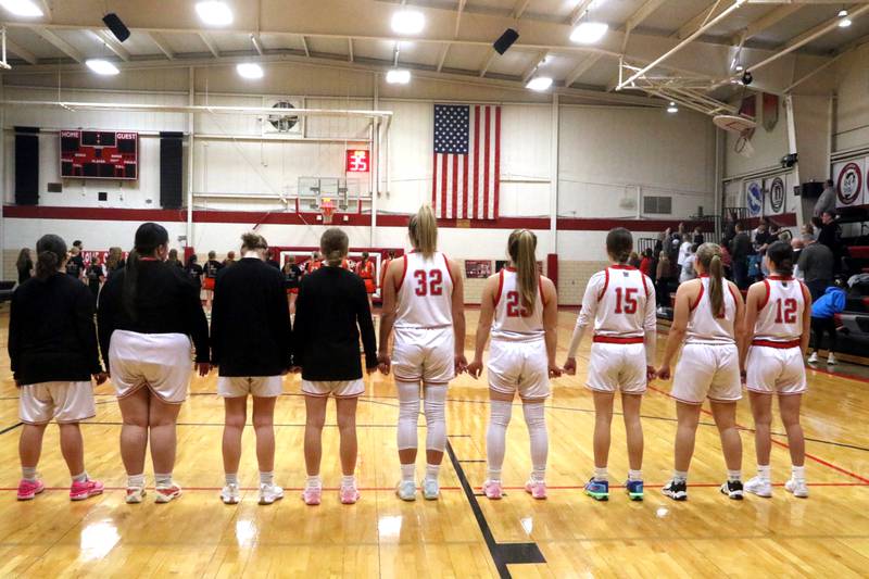 Orient-Macksburg's girls basketball team stands for the national anthem prior to their playoff game Thursday, Feb. 13 against Madrid.