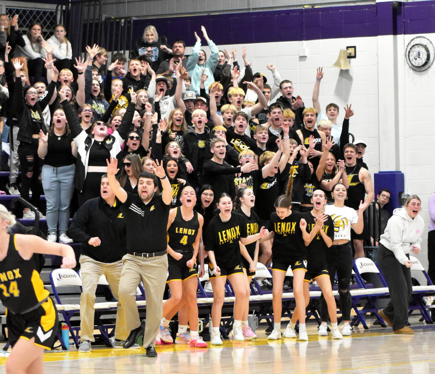 The Lenox bench and student section celebrates a 3-pointer made by senior Izzy Curtis in the first half.