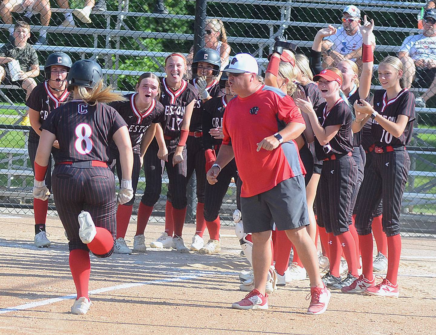 Coach Dave Hartman and teammates congratulate Jaycee Hanson (8) after the Panther first baseman hit a three-run home run in the opening game of Thursday's doubleheader. Hanson also hit a three-run homer in game two, finishing the day with seven RBIs.