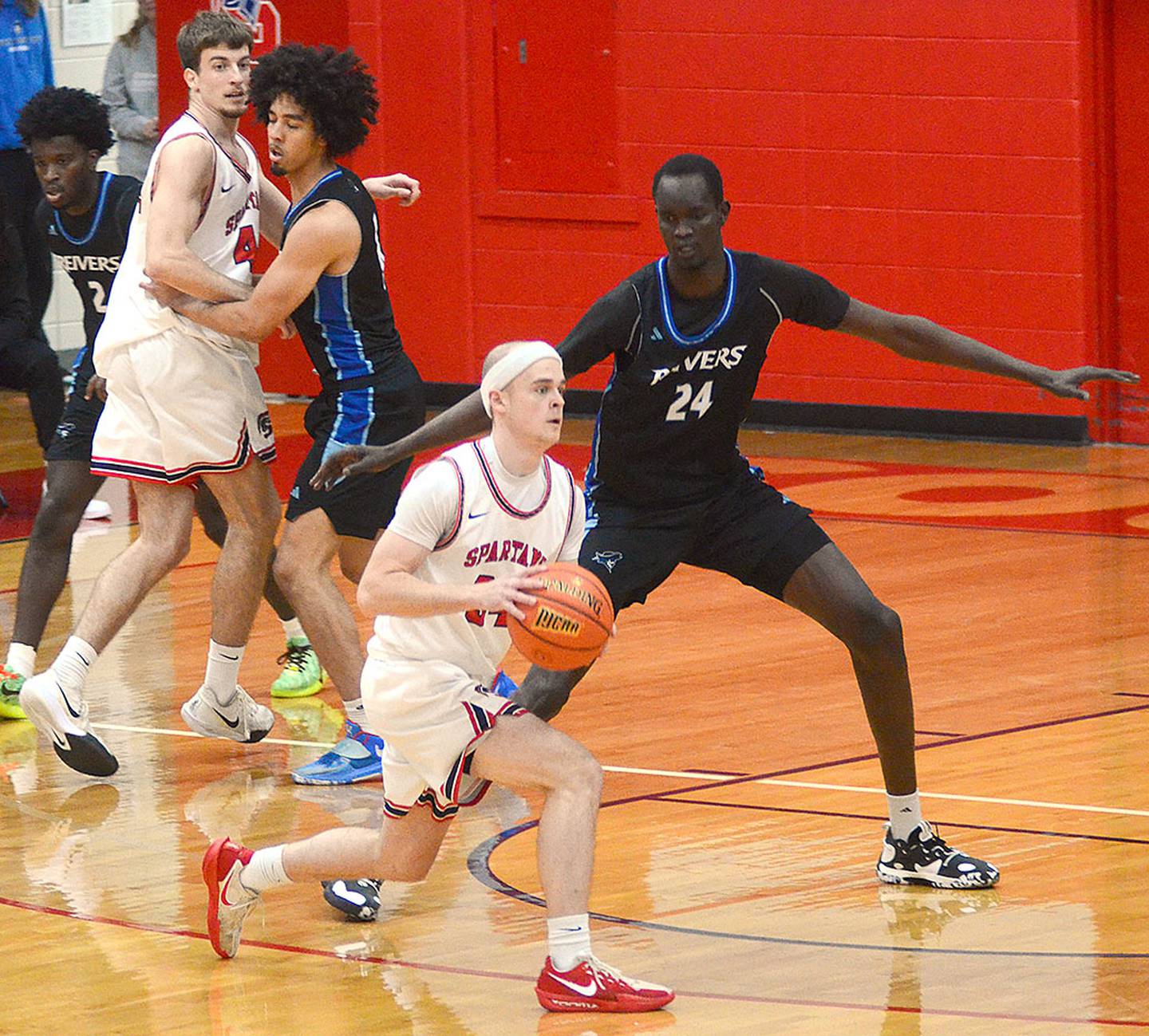 Southwestern sophomore Ethan Crawford of Creston, guarded by Iowa Western's 7-foot-2 center Madelo Deng, looks to pass to open teammate Tuesday. Crawford averaged 8 points a game for Creston in 2022-23.