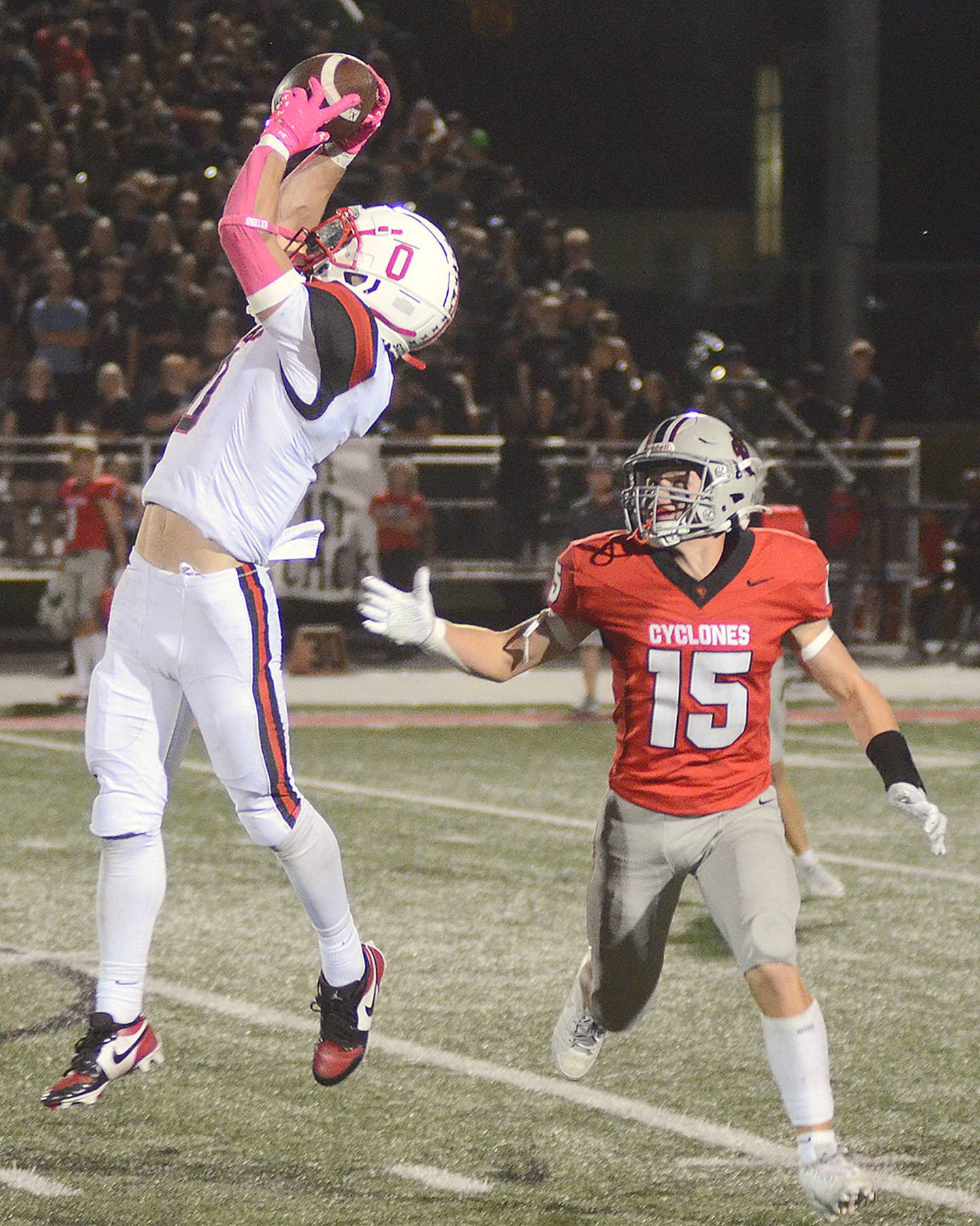 Creston's Seth Gordon (0) leaps to make a catch in front of Harlan's Kreed Boggess (15) for a 19-yard gain in the third quarter Friday. Gordon caught four passes for 77 yards.