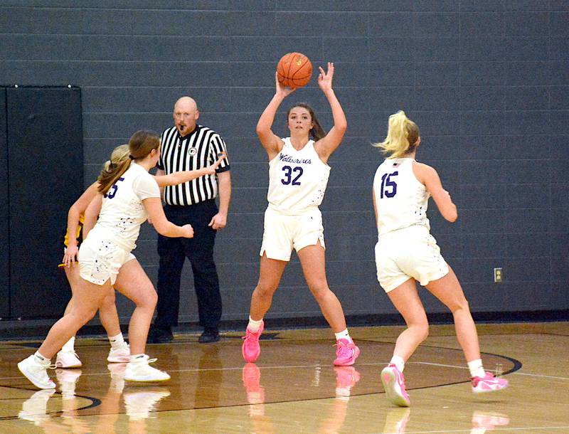 Wolverine senior Emma Boswell (32) dishes the ball out to senior Izzy Eisbach (15) on the perimeter last Tuesday against Lenox.