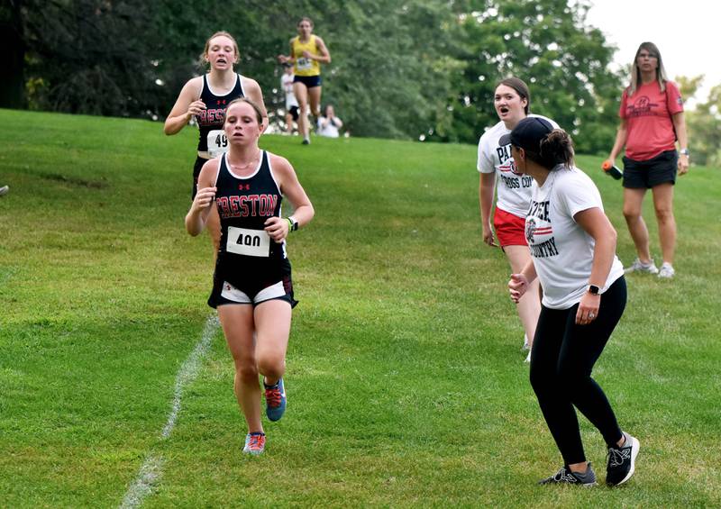 First year runners Karter Clayton, front, and Gretchen Hoepker are cheered on by coaches Maggie Arnold and Taylor Tanner. Hoepker finished 23rd and Clayton 24th. The team brought home a third place finish.
