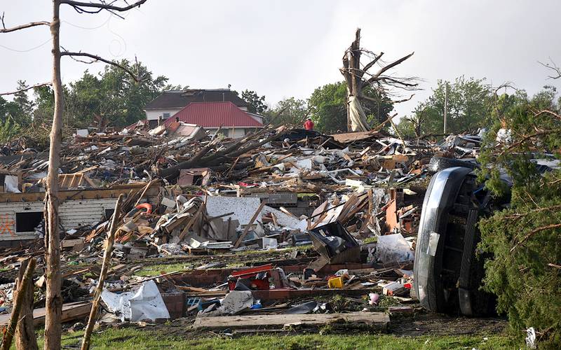 The ruins of homes are comprised of piles of debris, damaged vehicles and personal belongings. Homes that remain standing still face structural and roof damage.