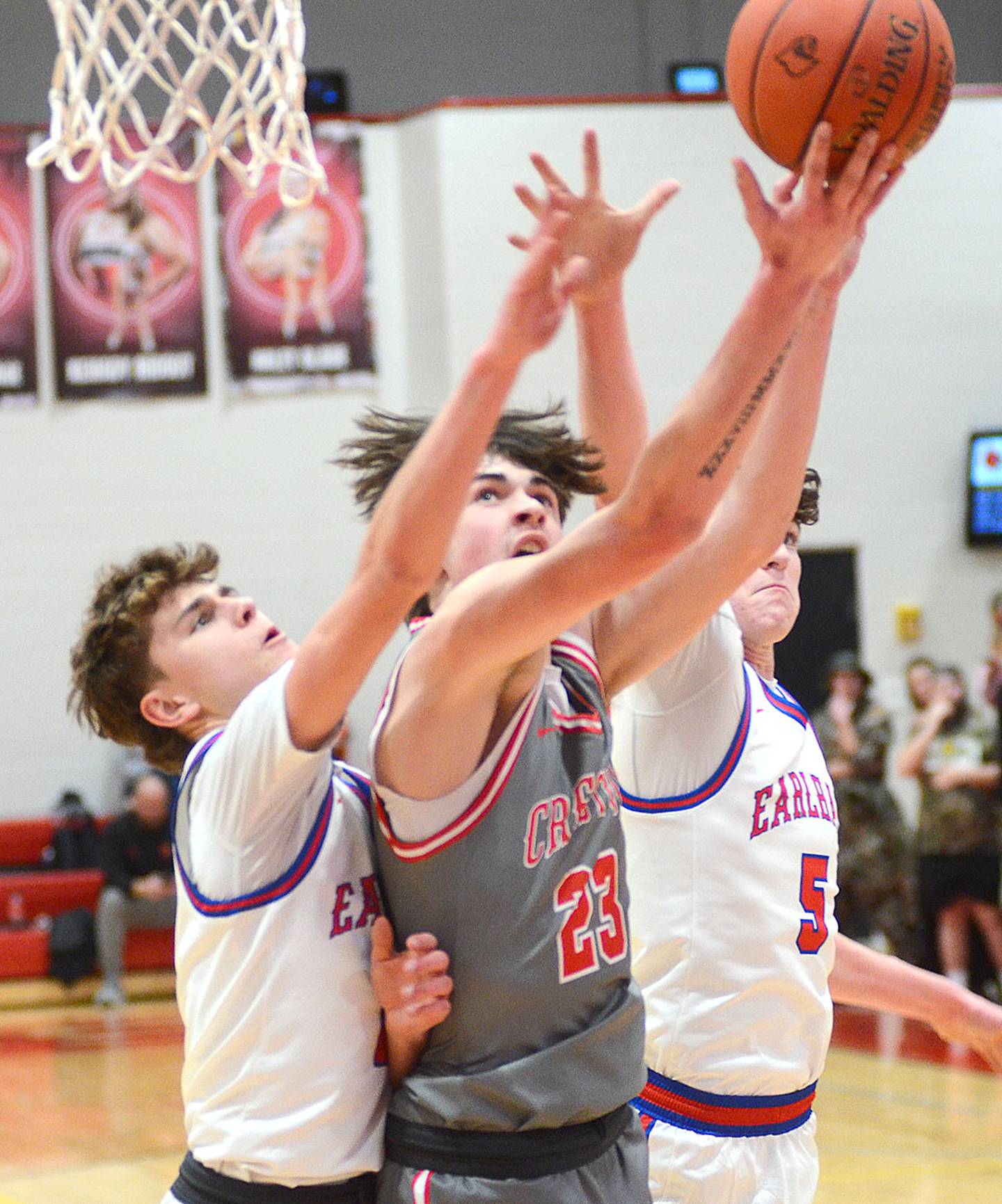 Jake Hoyt of Creston (23) slices through two Earlham defenders on a drive Thursday. Hoyt totaled 19 points and 19 rebounds in the 55-53 victory.