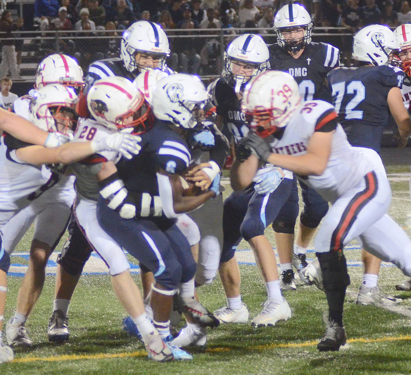 Kal Barber (28) and Blake Hayes (39) wrap up Des Moines Christian running back Davis Tokheim.