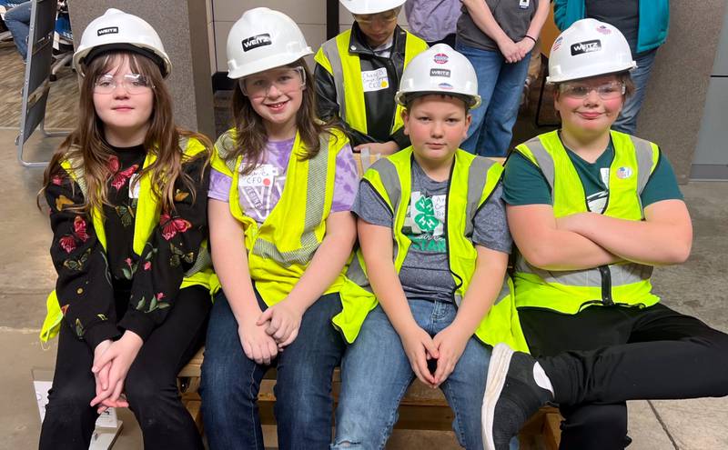 Nodaway Valley fifth graders working in the construction sector for a day during their Biztown field trip sit on a bench they constructed.