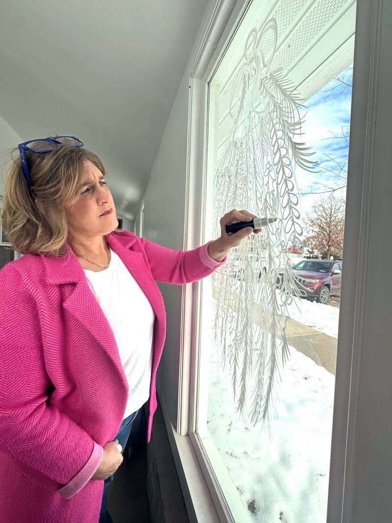 Denise Kuhns paints a wintry window at The Gathering Place in Greenfield.