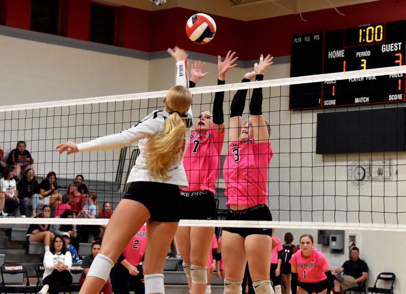 Hope Henderson (No. 7) and Jaycee Hanson (No. 3) jump for a block Tuesday in a 3-2 win over Harlan. Henderson had two solo blocks.
