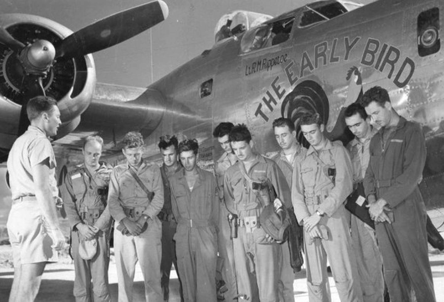 Chaplain Milton Dowden of Waterloo leads the crew of the 846th Bomb Squadron, 494th Bomb group in prayer before they talk off in the B-24 Liberator "The Early Bird." Sgt. Walter L. Lippert, fifth in the line of crew members, is from Burlington.