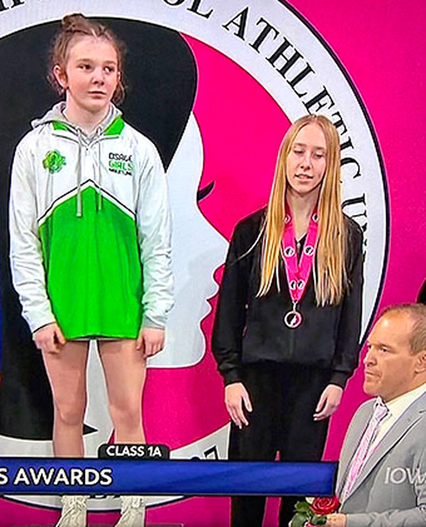 Ainsley Hemann of Osage (left) is about to receive her gold medal in Class 1A 105 pounds from her father and coach, Nick Hemann, a former Creston assistant coach.