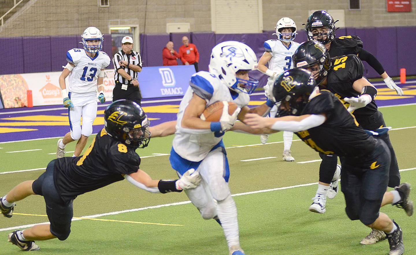 Wylie Brokaw (12) and Jack Reed (8) tackle Gladbrook-Reinbeck kick returner Treyvon Herron during Wednesday's semifinal game in the UNI-Dome.