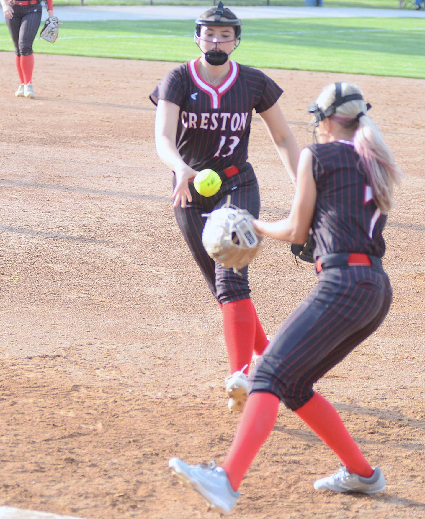 First baseman Rohwyn Randall flips the ball to second baseman Peyton Veitz covering the base after Randall fielded a ground ball Thursday against Red Oak.