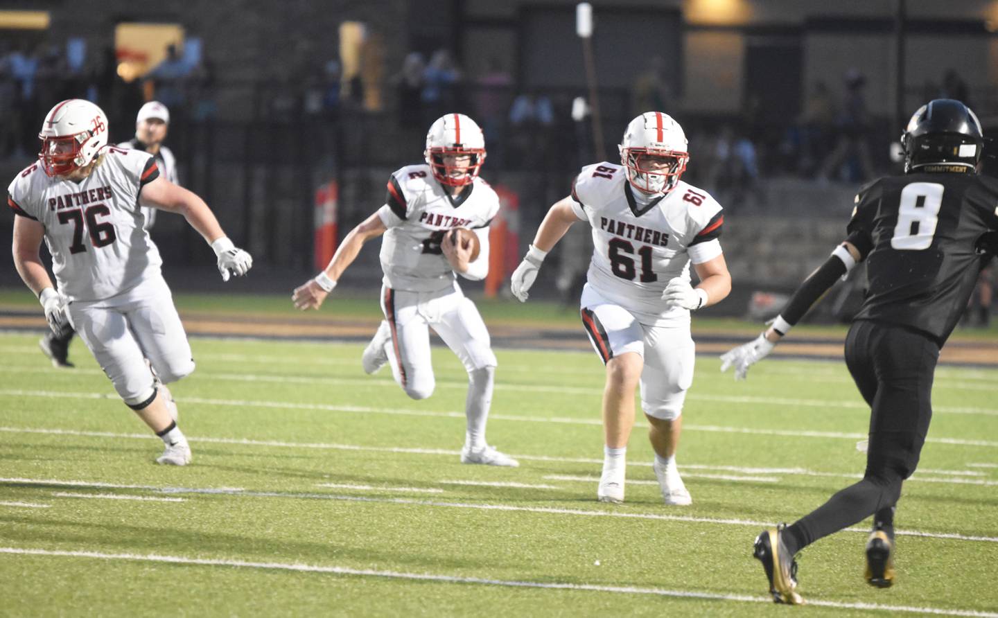 Quarterback Tanner Ray follows senior offensive linemen Gunner Martwick (76) and Garrick Clausen (61) on a quarterback keeper.