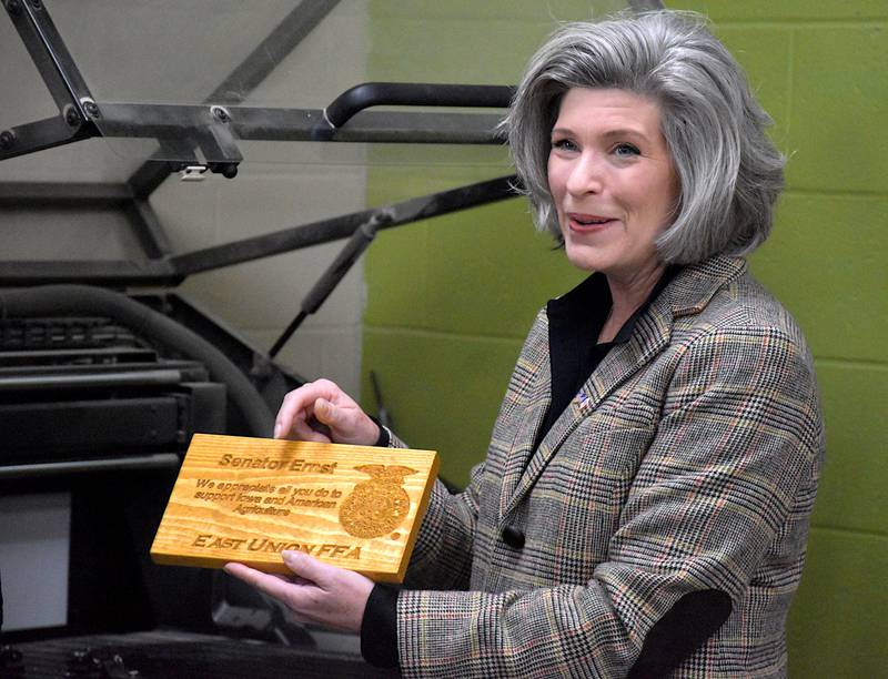 Iowa Sen. Joni Ernst holds a wooden plaque etched with her name and the FFA symbol given to her Friday by the East Union FFA chapter. She visited the school Friday.