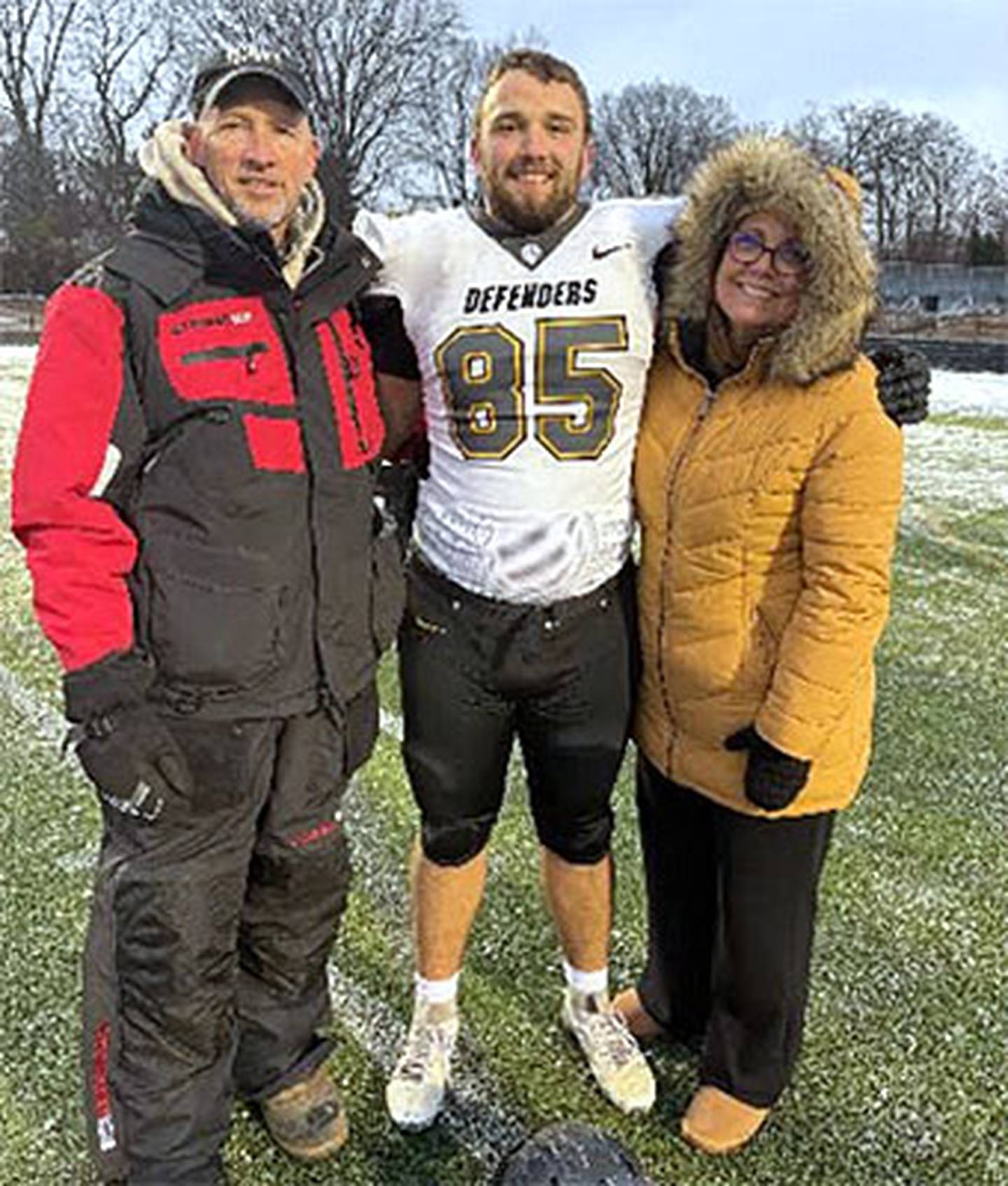 Shown with Dordt's Derek Paup at the playoff game vs. Marian University in Indianapolis are his father Chad and mother Jodi.