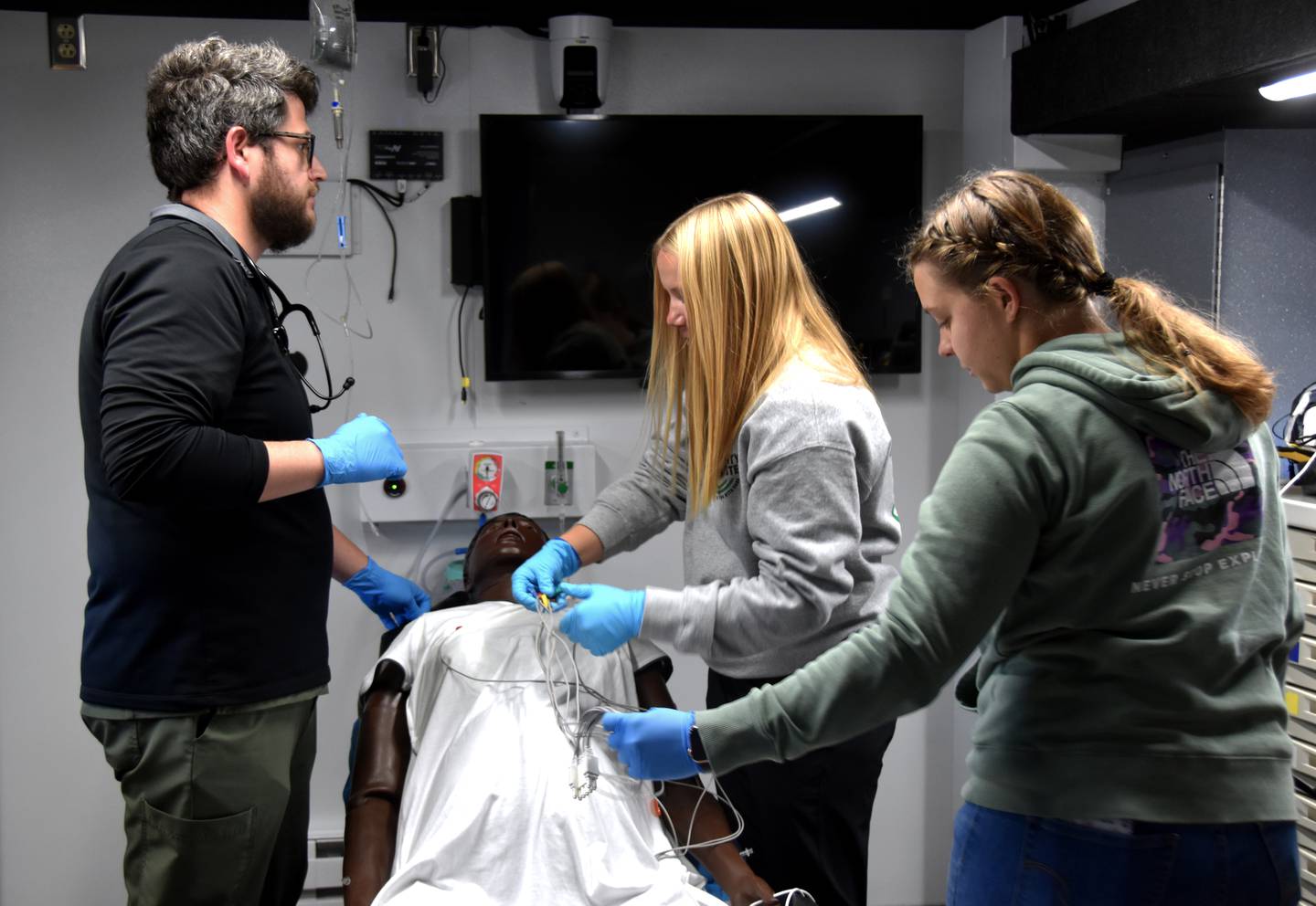 ER nurses practice a scenario in a MercyOne “Simulation in Motion” truck that allows training staff to manipulate patient vitals and communicate as the patient.