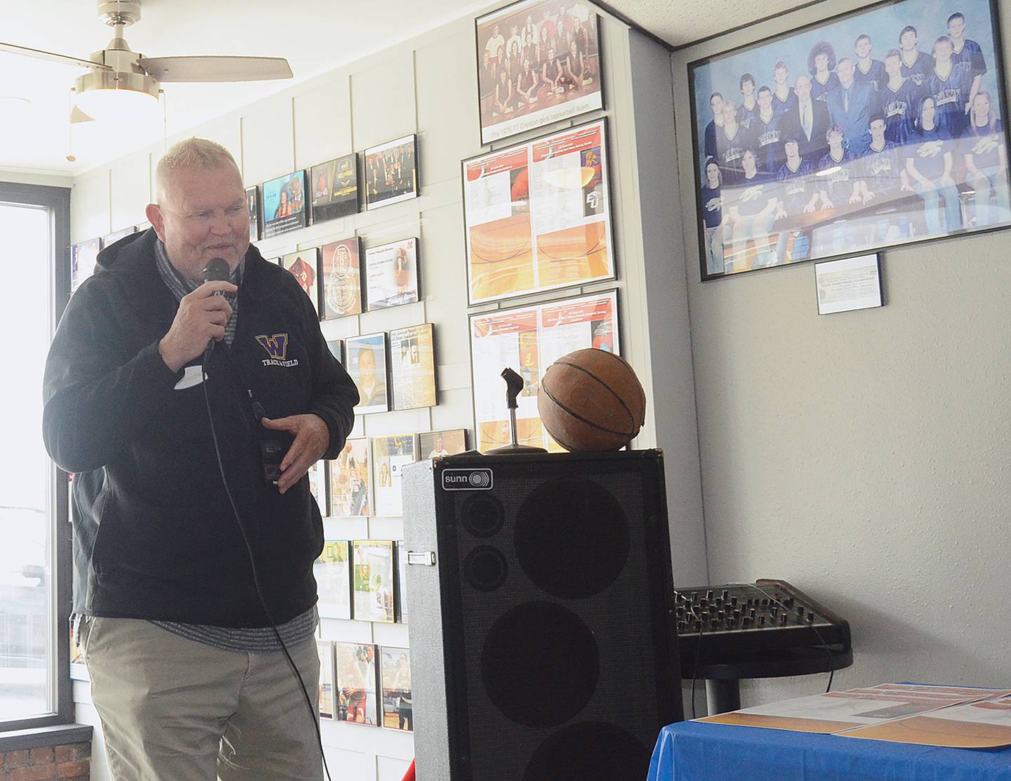 Iowa Basketball Hall of Fame coach Darrell Burmeister, who won 603 games as coach at Nodaway Valley and Bridgewater-Fontanelle, shared memories of his teams during Saturday's program. The photo of his 2006 state championship team is shown on the wall at right.