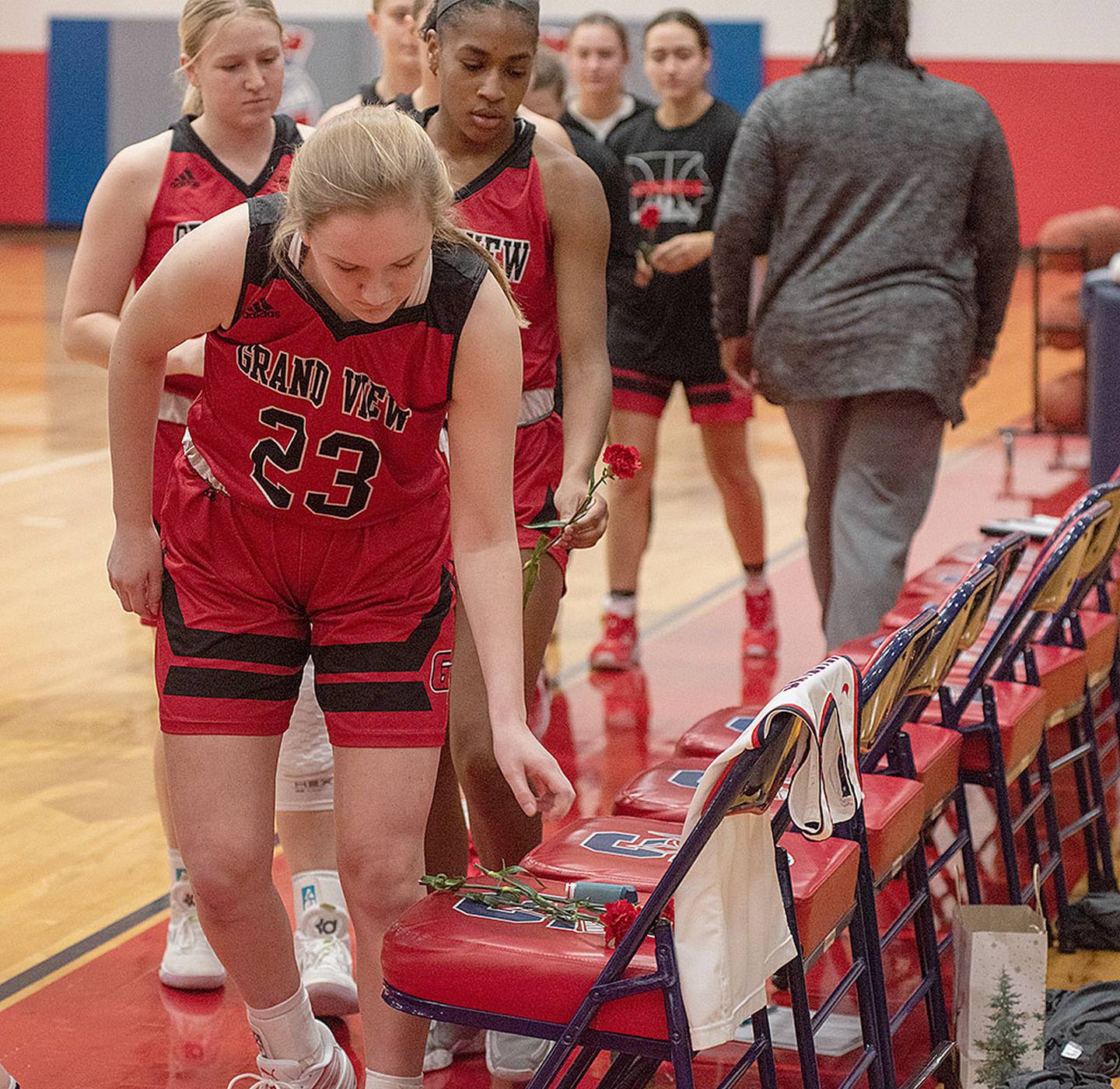 Grand View JV players each placed a carnation on the bench seat in Maddie Stewart's honor before the start of Monday's game against the Spartans.