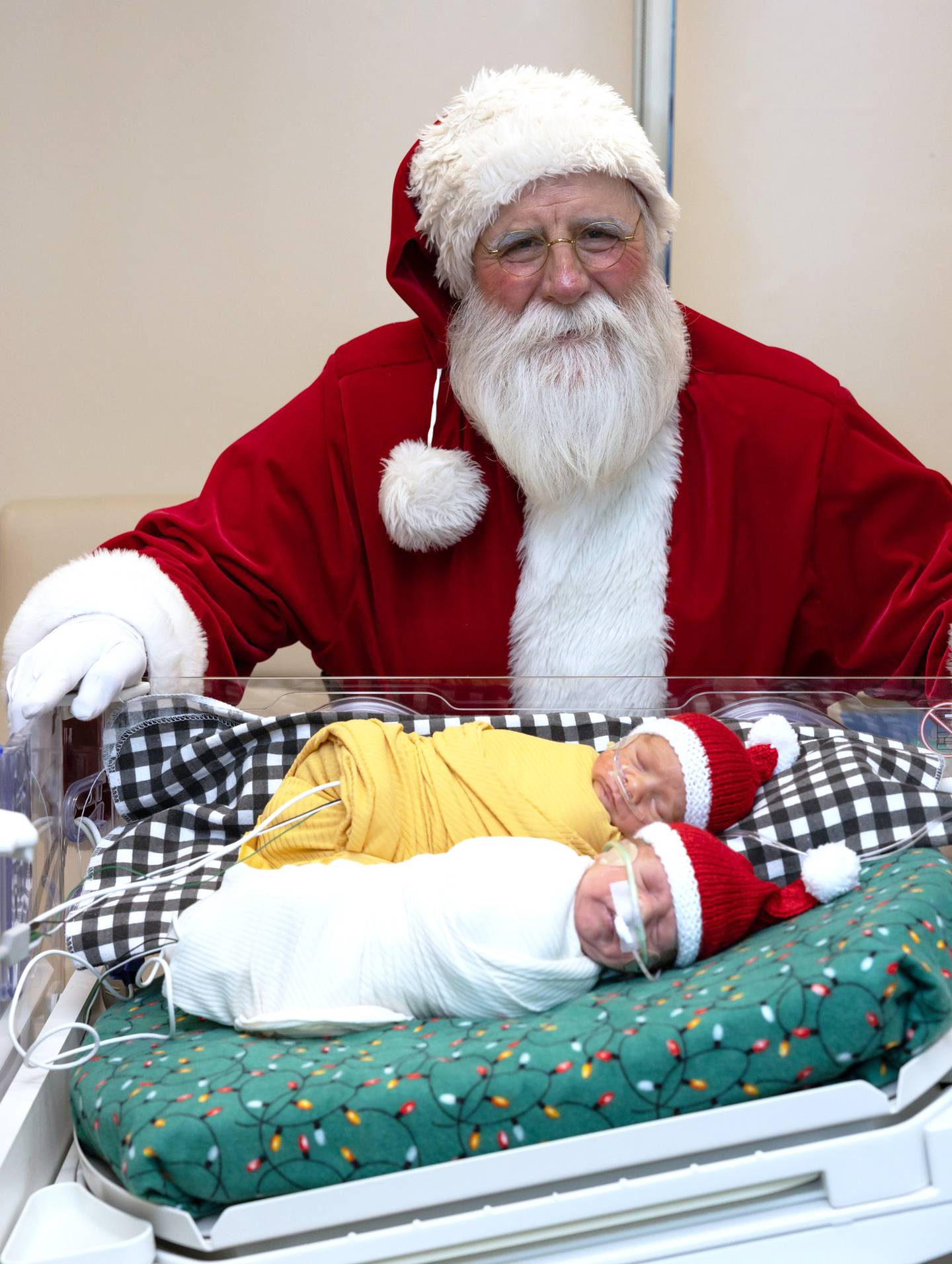 Santa visits twins Alexander and Asher Crall at the Mercy NICU in Des Moines as one of his 86 events this holiday season.