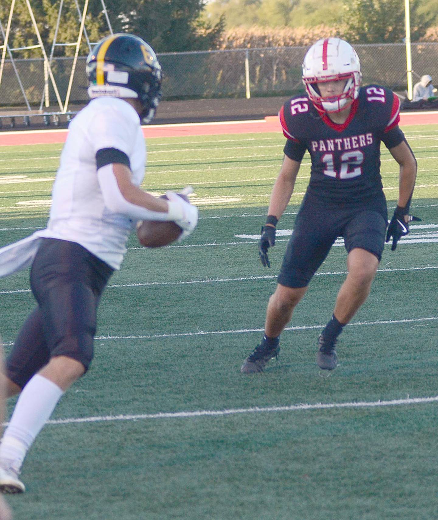 Creston cornerback Joaquin Flores (12) closes in on a Winterset pass receiver last week. Flores is also the team's punter (42.7 average) and placekicker (4-4 PATs, three kickoff touchbacks).