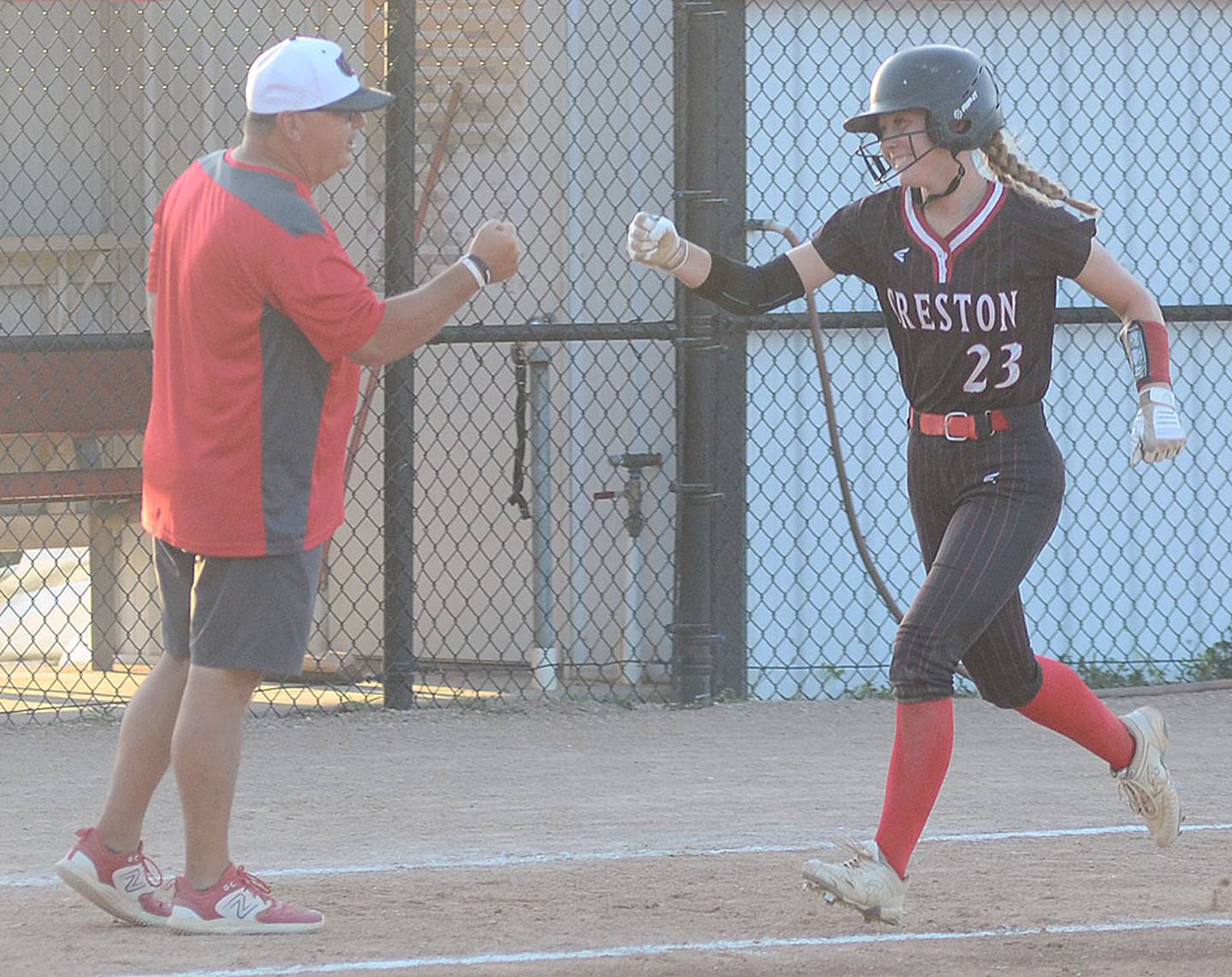 Creston coach Dave Hartman congratulates Avery Staver as she rounds third base after hitting a home run in the fifth inning to tie Clarinda, 5-5. It was Staver's 13th home run of the season, second-highest total in a season in program history.