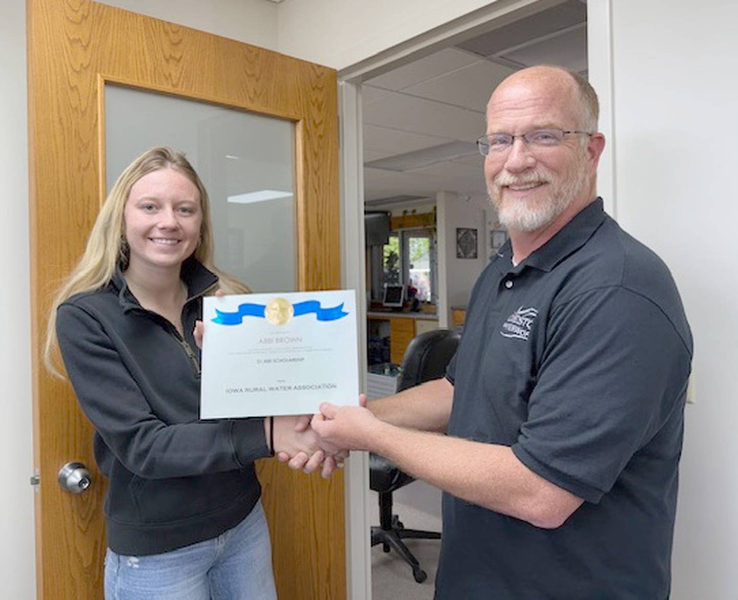 Abbi Brown receives a $1,500 IRWA scholarship from Creston Waterworks general manager Steve Guthrie.
