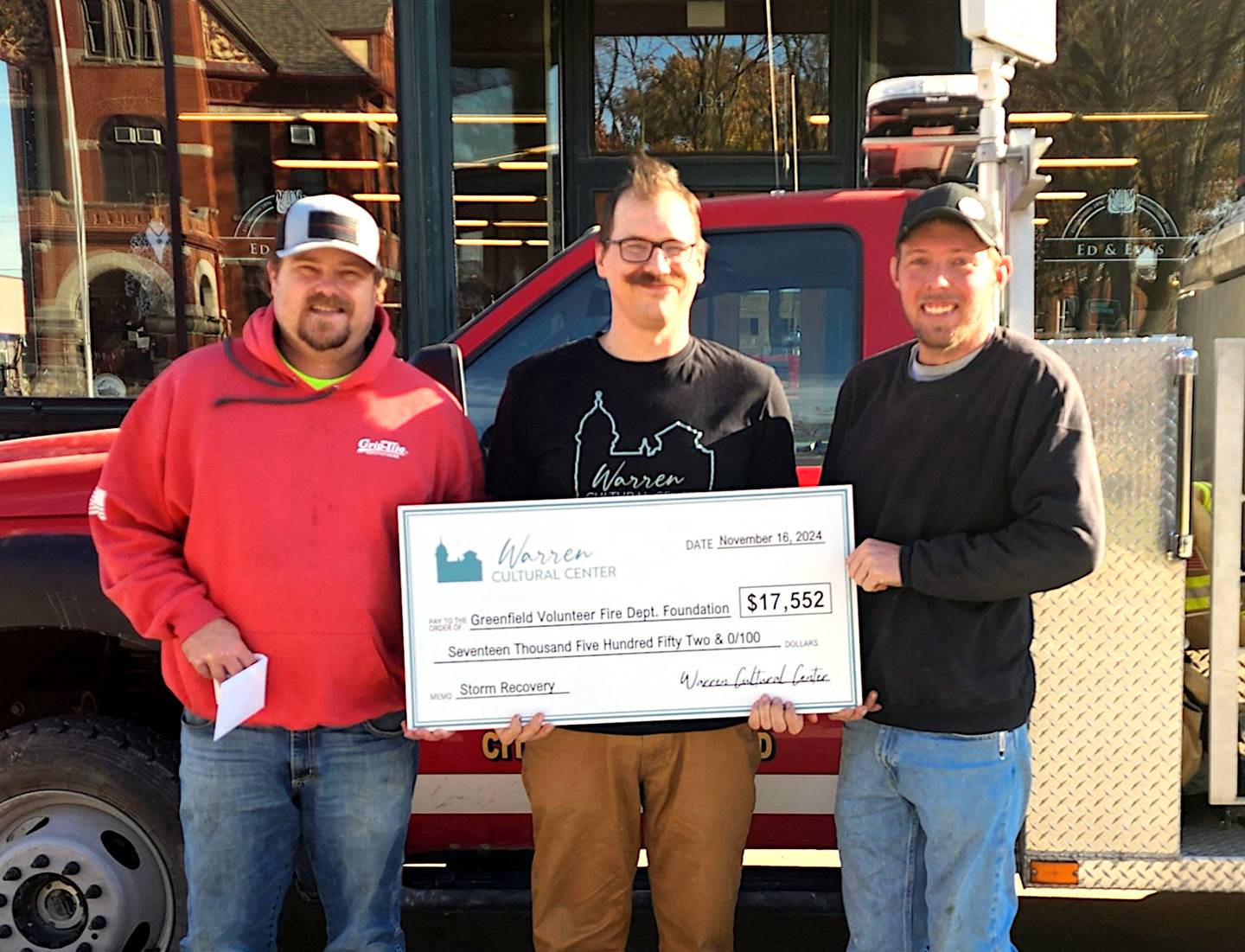 Greenfield firefighters Lance McFarland and TJ Oder accept a check from Thaddeus Hawley (middle) of the Warren Cultural Center.