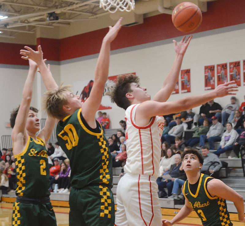 Creston's Parker Varner slices through St. Albert defenders for a reverse layup in the second half of Tuesday's 59-56 loss to the Falcons. Varner scored a team-high 16 points.