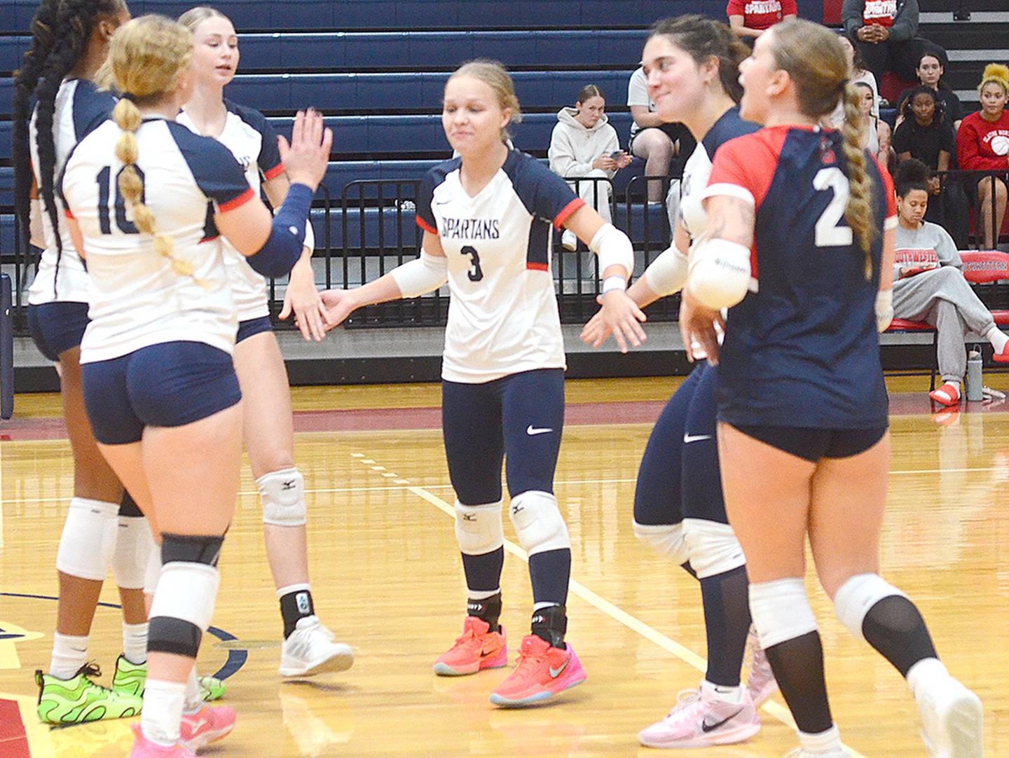 Southwestern setter Savanna Marriott (3) celebrates with teammates after a Spartan kill gave the Spartans an 8-5 lead in set one. Marriott finished with a team-high 10 assists.