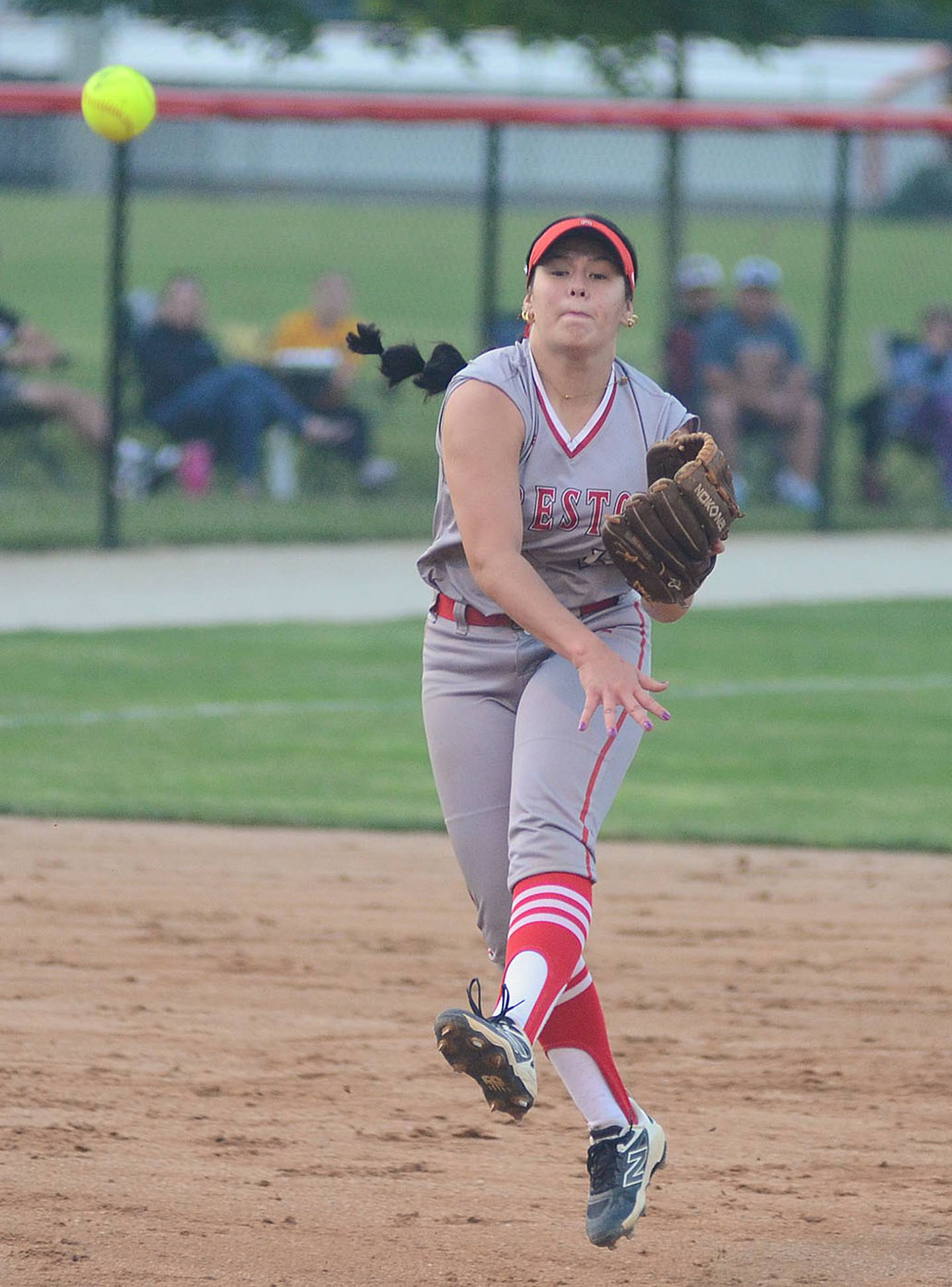 Creston shortstop Mila Kuhns makes a running throw to first base after fielding a ground ball Wednesday. Kuhns hit a two-run home run in the third inning.