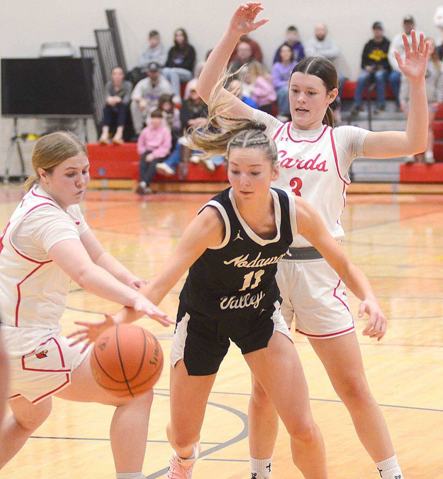 Abigail Nelson of Nodaway Valley (11) battles two Earlham players for a loose ball in Friday's regional semifinal game. Nelson had seven points and eight rebounds.