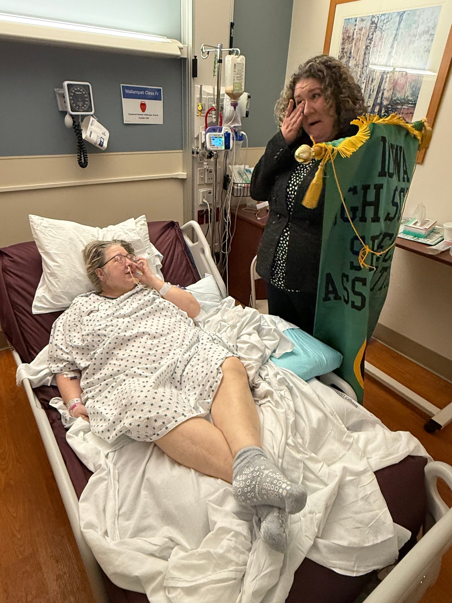 Laura Granger, right, sheds a tear while presenting Creston's banner to her mother, Julie. Known as "Mama Granger" to the students, Julie assisted with the speech team before she suffered a stroke.
