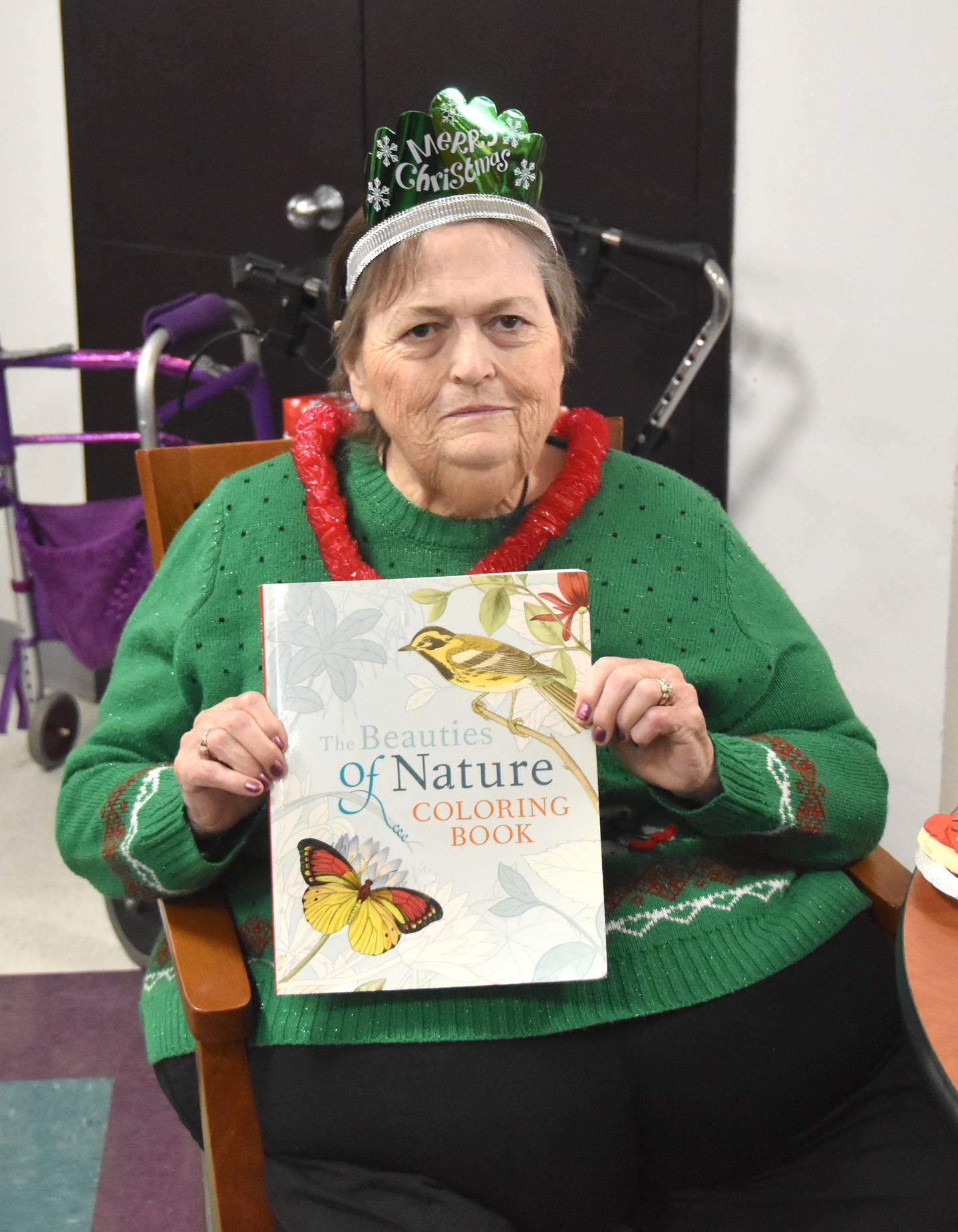 Beverly Sage shows off one of her Christmas presents during the holiday party at Creston Specialty Care.