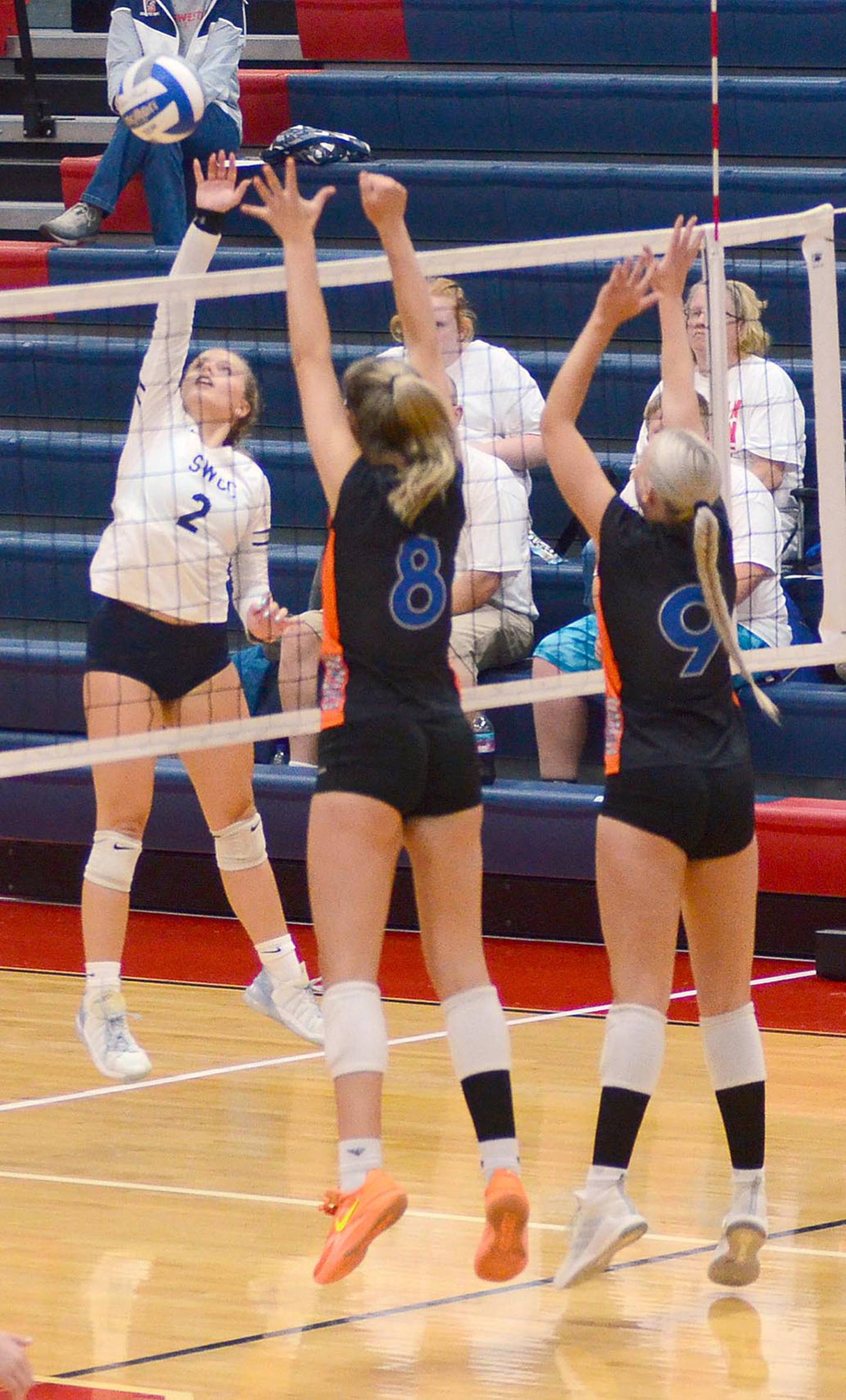 Southwestern's Meredith Gettings (2) sends an attack past two Hawkeye Community College blockers during Tuesday's match. Gettings had a block and two ace serves in the loss.