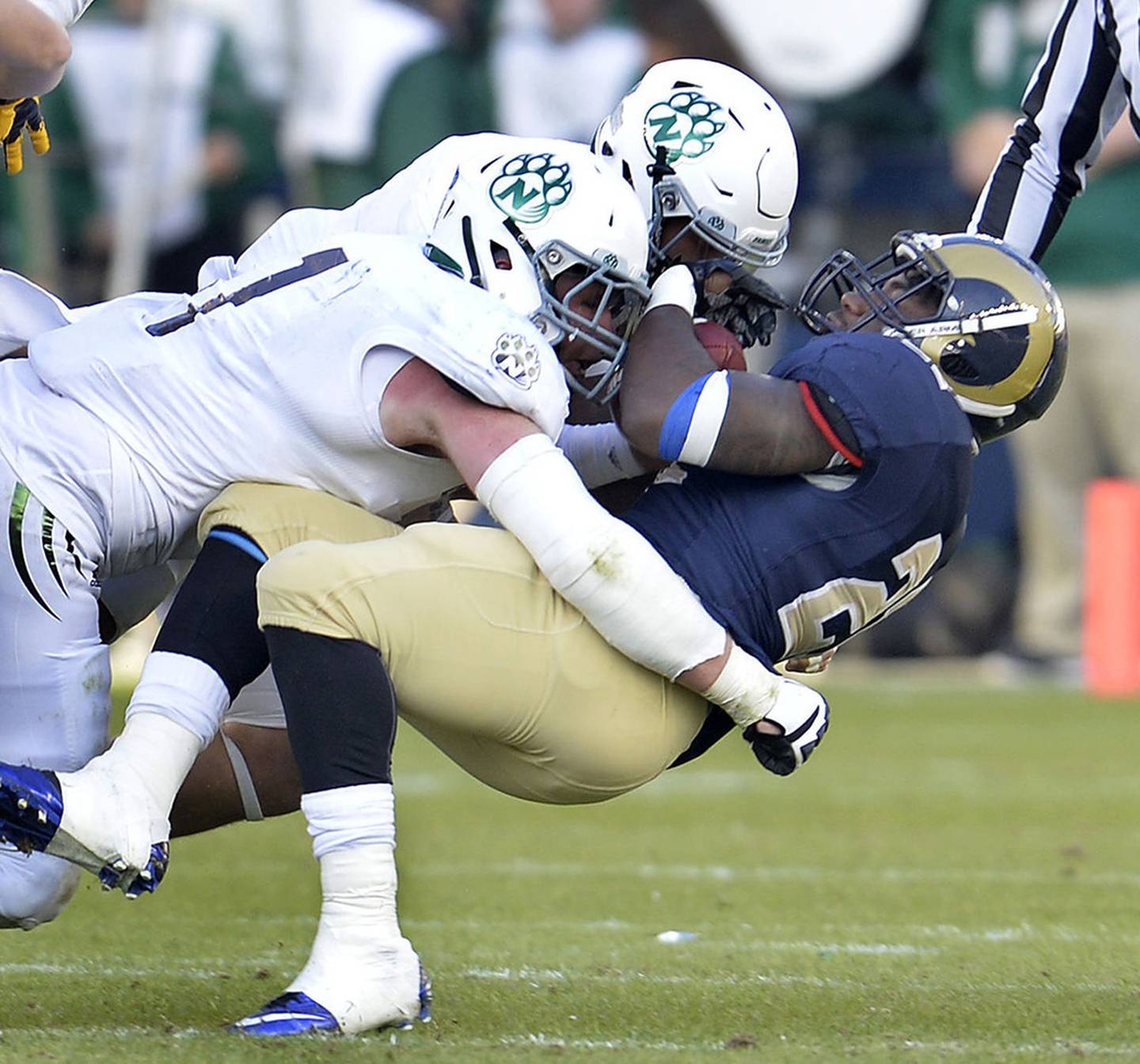 Collin Bevins (left) and a teammate make a tackle during the 2015 national championship season. Bevins twice earned All-American honors as a defensive end.