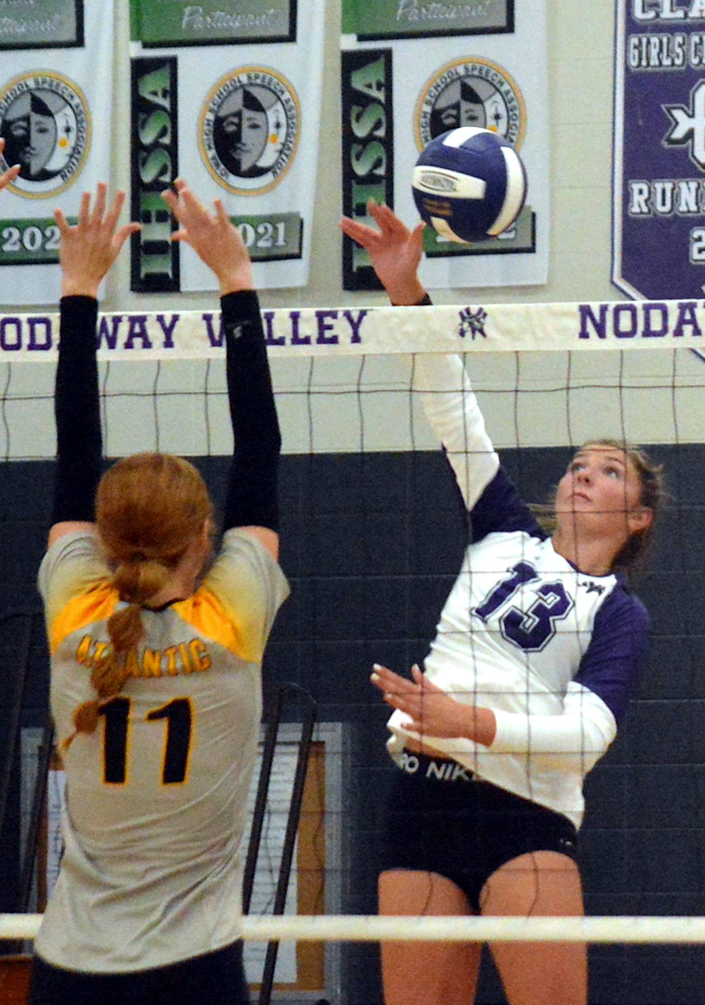 Nodaway Valley/OM senior Emma Boswell (13) reads Atlantic's block on a kill attempt in last Thursday's non-conference match with the Trojans.
