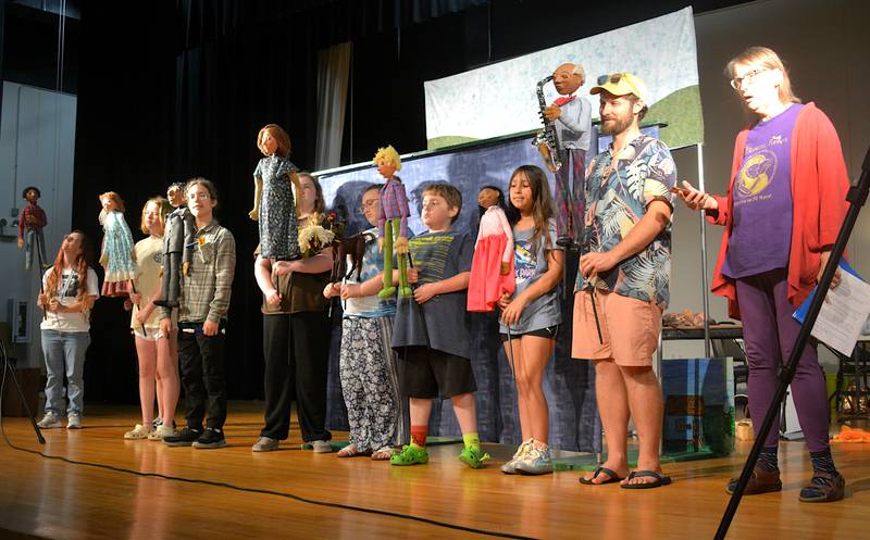 The afternoon at the end of their run-through on Wednesday, June 26. Members of the Eulenspiegel Puppet Theatre stand with the kids, who show off the puppets they performed with.