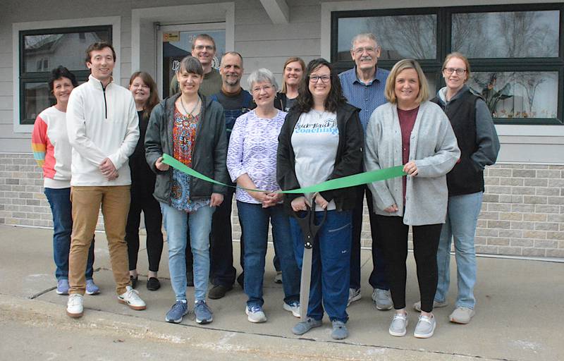 Amanda Cannon (holding the giant scissors second from right in front) with family members and Greenfield leaders from Greenfield Chamber Main Street and the city at her ribbon cutting for Brick By Brick Coaching last Tuesday.