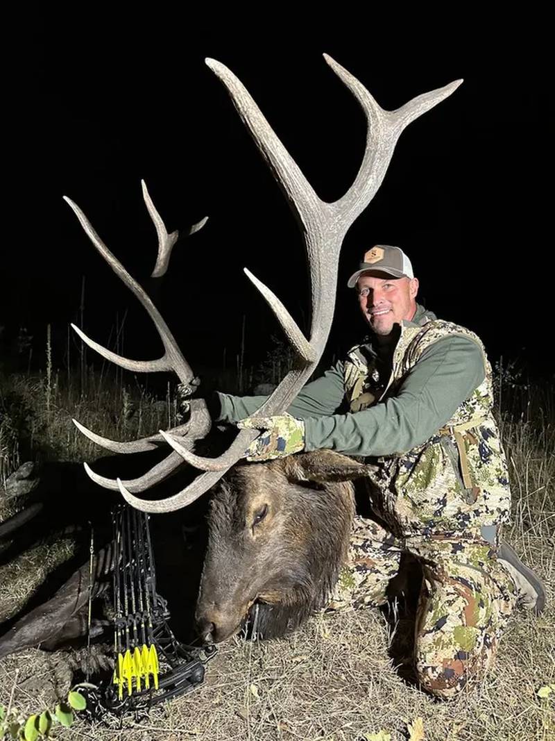 Marty Edwards with a prize buck, alongside a bow and arrows.