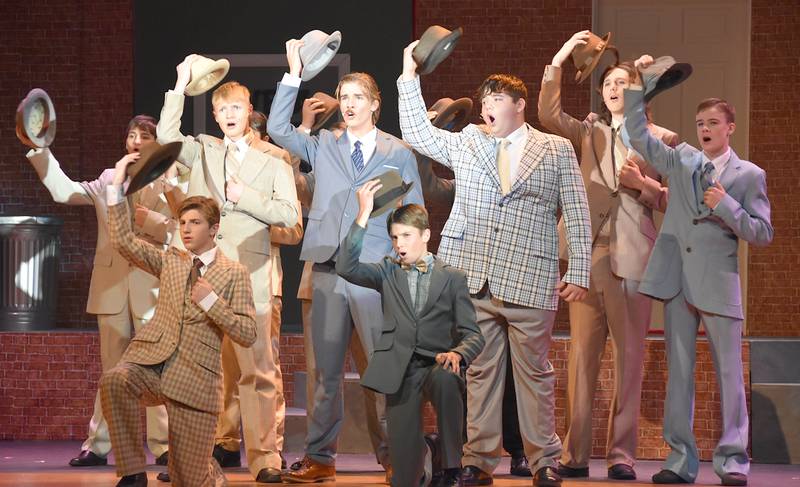 The male ensemble of "Guys and Dolls" takes off their hats during a musical number.