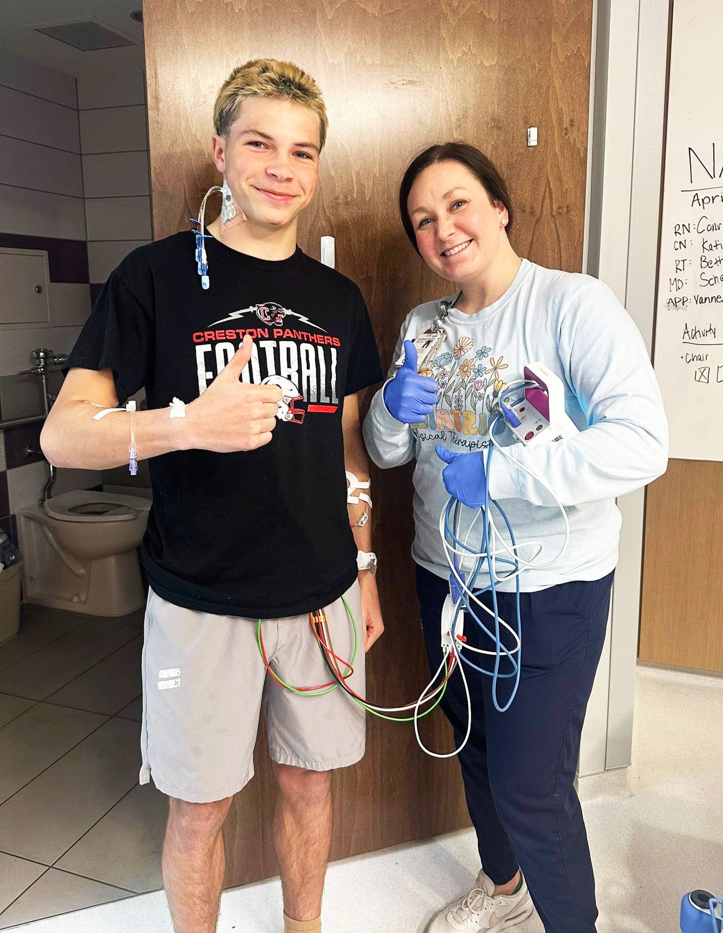 Creston freshman Nate Bentley gives a thumbs up with his physical therapist at Children's Nebraska in Omaha only days after his heart stopped on the track in Glenwood.